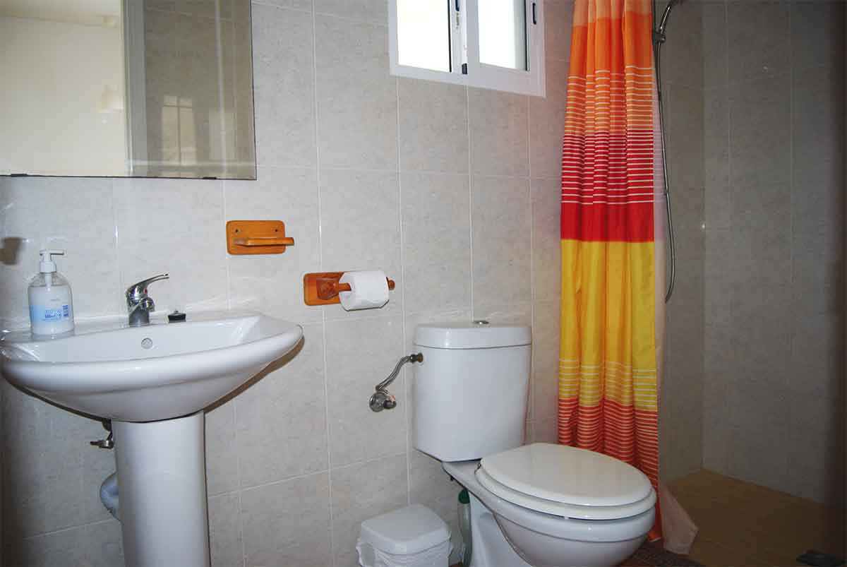 Accommodatie Een foto van de badkamer in de Riverside finca met de wastafel, het toilet en de douche