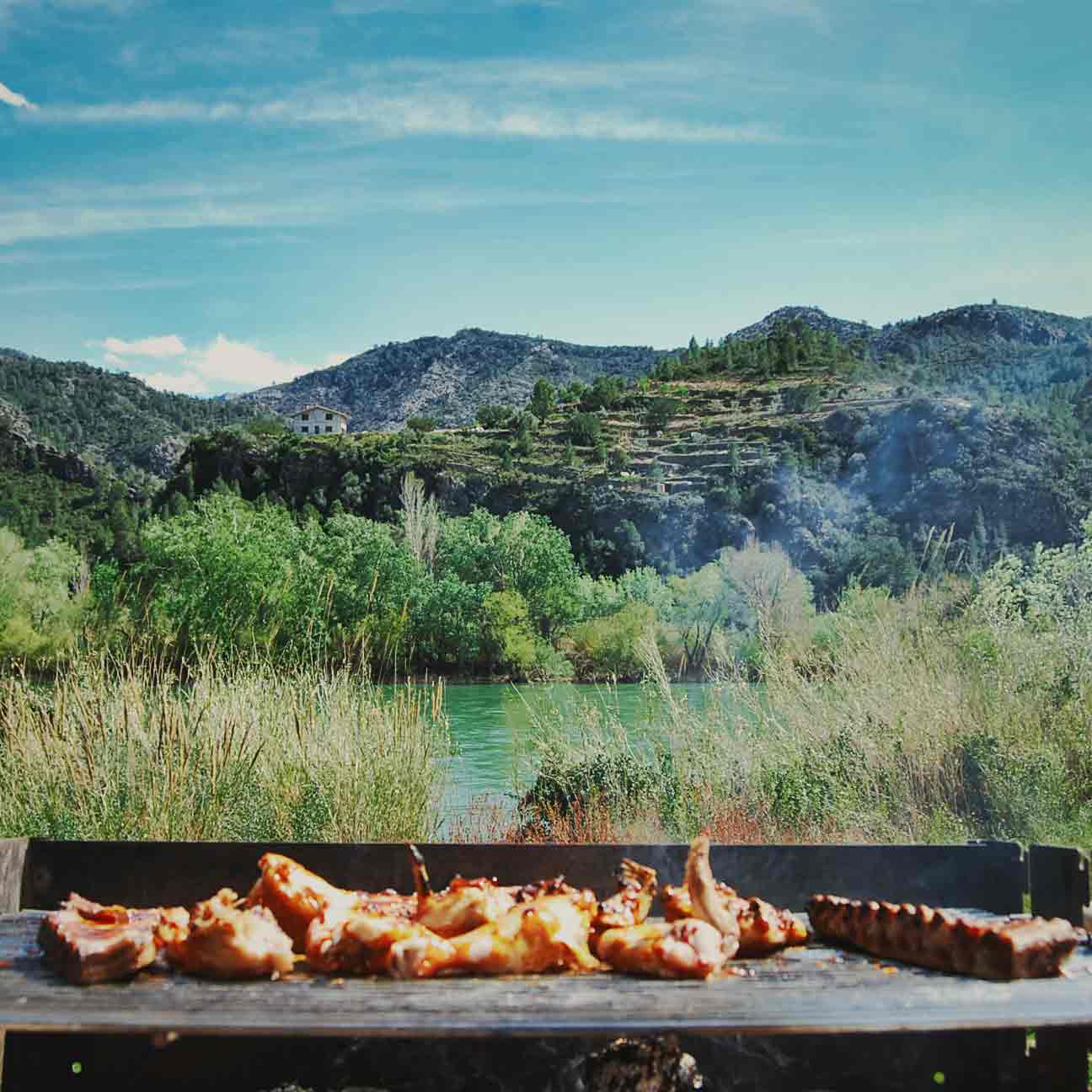Home Foto van een barbecue met kip en ribbetjes op het terras van de Riverside Finca met uitzicht op de rivier de Ebro en de bergen van Catalonië