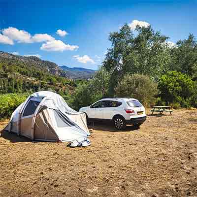 Accommodatie Foto van een grote tent en een SUV en een picknicktafel op het land bij de Riverside Finca in Benifallet