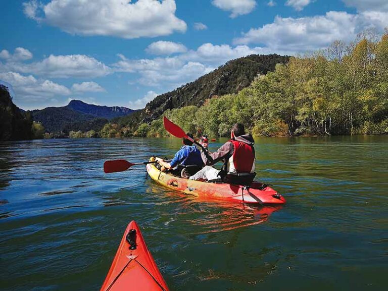 A father and son kayaking from Miravet to Benifallet on the Ebro River surrounded by mountains