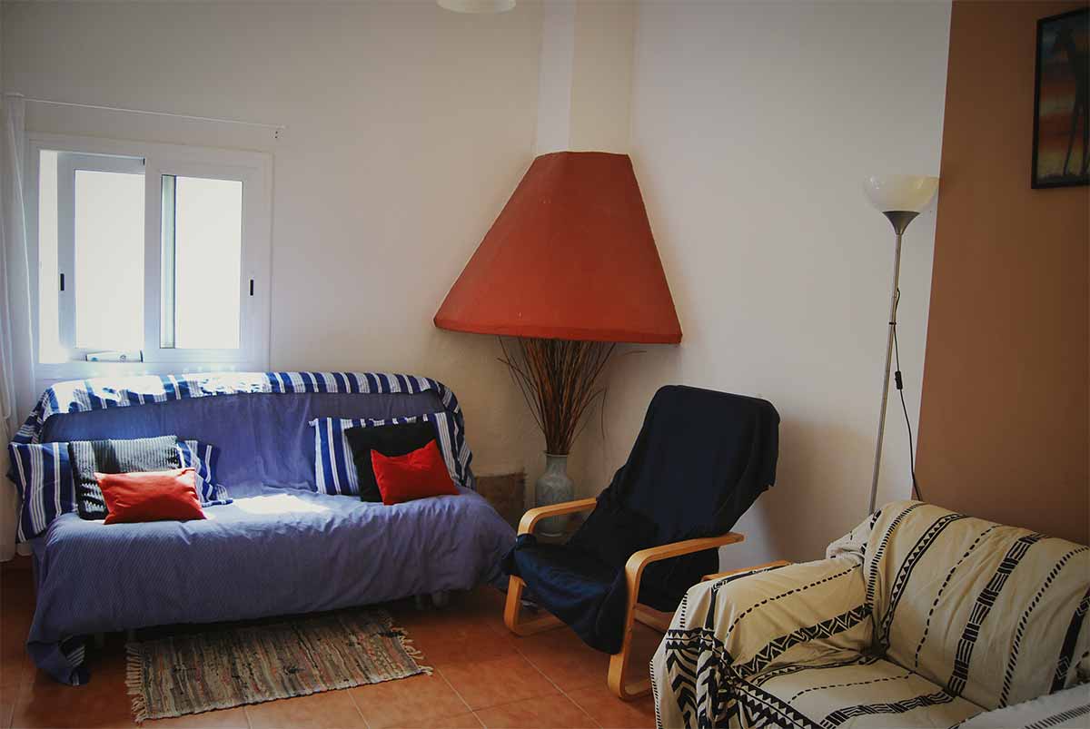 Accommodatie Foto van de zitkamer in de Riverside Finca met een bank, stoel en zachte fauteuil