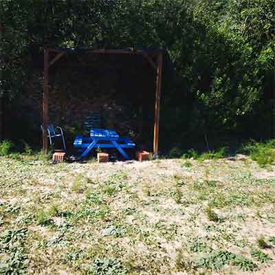 Accommodatie Een afbeelding van de schaduwrijke pergola met een stoel en picknicktafel eronder