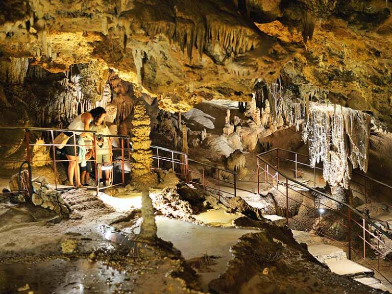 The Coves Meravelles: Benifallet's Underground Wonder Photo of a family looking at the rock formations inside the spectacular Coves Meravelles in Benifallet